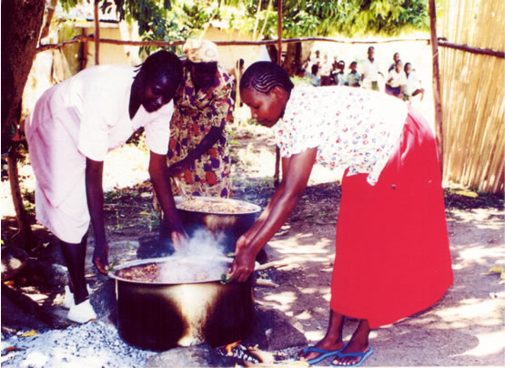 Academy staff cooking in large pots over open fires